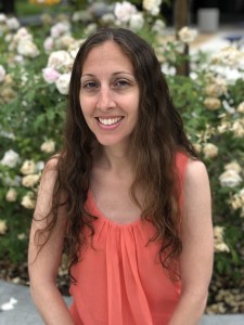 Photo of Dawn Decker, Treasurer of CAPED with flowers and trees behind her